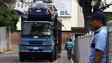 A truck loading new General Motor (GM) cars drives out of a GM assembly plant in Valencia, Venezuela, on June 19, 2009. The assembly plant was temporarily shut down for 3 months because it cannot import car parts timely.