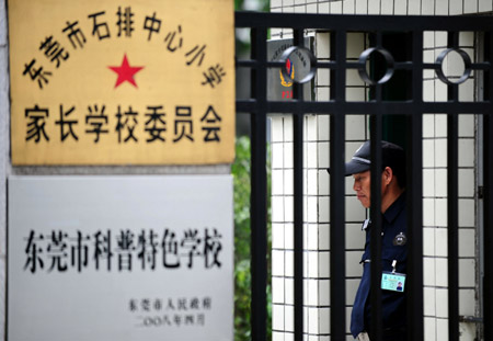 Photo taken on June 20, 2009 shows a security guard stands next to the closed door of Shipaizhen central primary school, where six new cases of A/H1N1 flu had been confirmed in Dongguan, south China's Guangdong Province on Friday June 19, 2009. 