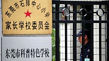 Photo taken on June 20, 2009 shows a security guard stands next to the closed door of Shipaizhen central primary school, where six new cases of A/H1N1 flu had been confirmed in Dongguan, south China's Guangdong Province on Friday June 19, 2009.