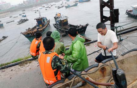 People tighten mooring fishing boats to brace for the upcoming Linfa, the third tropical storm this year, at a port in Jinjiang, a city in southeast China's Fujian Province, on June 21, 2009. Linfa has upgraded to strong tropical storm on June 20, and an emergency alarm was issued by the provincial weather bureau. 