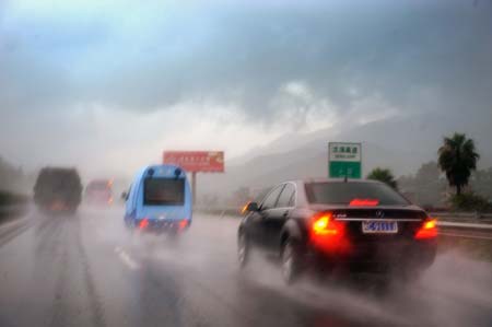 Vehicles are moving in the heavy rain on a highway as Linfa, the third tropical storm this year, is approaching in southeast China's Fujian Province, on June 21, 2009. Linfa has upgraded to strong tropical storm on June 20, and an emergency alarm was issued by the provincial weather bureau. 