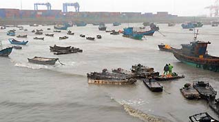 Fishing boats are moored as people brace for the upcoming Linfa, the third tropical storm this year, at a port in Jinjiang, a city in southeast China's Fujian Province, on June 21, 2009. Linfa has upgraded to strong tropical storm on June 20, and an emergency alarm was issued by the provincial weather bureau.