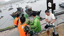 People tighten mooring fishing boats to brace for the upcoming Linfa, the third tropical storm this year, at a port in Jinjiang, a city in southeast China's Fujian Province, on June 21, 2009. Linfa has upgraded to strong tropical storm on June 20, and an emergency alarm was issued by the provincial weather bureau.