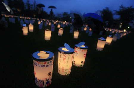 Plastic cups with candles in are set during the Candle Night campaign to call for saving the electricity with the lights off in Roppongi in Tokyo, capital of Japan, on June 21, 2009. 