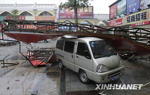 A billboard brought down by strong winds fell on a car on the street of Chendai Township, Jinjiang city of east China's Fujiang Province on Sunday, June 21, 2009. The provincial meteorological bureau issued an orange alert for torrential rains on Monday, after tropical storm Linfa arrived on Sunday. 