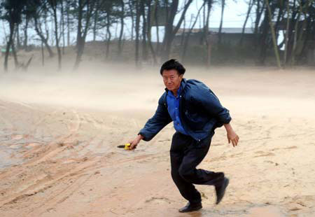 A local villager walks against strong gales at Jinjing Town in Jinjiang, a city in southeast China's Fujian Province, Sunday, on June 21, 2009. Linfa, the third tropical storm this year, landed at Dongshi Town, Jinjiang City on June 21. 