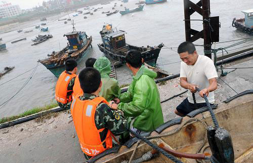 People tighten mooring fishing boats to brace for the upcoming Linfa, the third tropical storm this year, at a port in Jinjiang, a city in southeast China's Fujian Province, Sunday, on June 21, 2009. Linfa has upgraded to strong tropical storm on June 20, and an emergency alarm was issued by the provincial weather bureau.