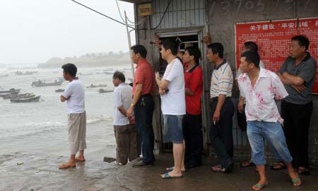 People watch their fishing boats as they brace for the upcoming Linfa, the third tropical storm this year, at a port in Jinjiang, a city in southeast China's Fujian Province, Sunday, on June 21, 2009. Linfa has upgraded to strong tropical storm on June 20, and an emergency alarm was issued by the provincial weather bureau. 