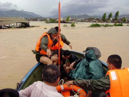 Soldiers of the local frontier defence troop rescue trapped residents in Zhao'an County, southeast China's Fujian Province, on June 22, 2009. Affected by tropical storm Linfa, the third this year, heavy rainstorm hit Zhao'an county on Sunday night. Over 100 residents trapped by floods have all been transferred to safe areas by Monday afternoon.