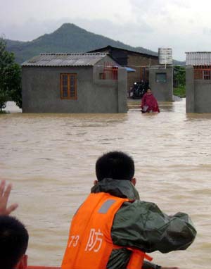 Soldiers of the local frontier defence troop rescue trapped resident in Zhao'an County, southeast China's Fujian Province, on June 22, 2009. Affected by tropical storm Linfa, the third this year, heavy rainstorm hit Zhao'an county on Sunday night. Over 100 residents trapped by floods have all been transferred to safe areas by Monday afternoon. 