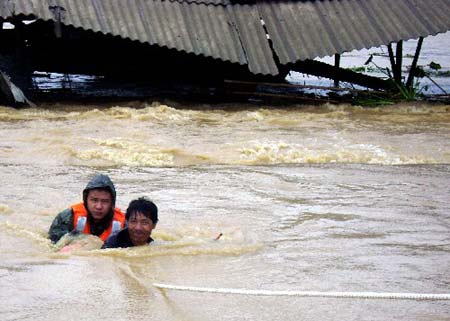 Soldiers of the local frontier defence troop rescue trapped resident in Zhao'an County, southeast China's Fujian Province, on June 22, 2009. Affected by tropical storm Linfa, the third this year, heavy rainstorm hit Zhao'an county on Sunday night. Over 100 residents trapped by floods have all been transferred to safe areas by Monday afternoon.