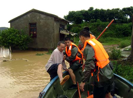 Soldiers of the local frontier defence troop rescue trapped resident in Zhao'an County, southeast China's Fujian Province, on June 22, 2009. Affected by tropical storm Linfa, the third this year, heavy rainstorm hit Zhao'an county on Sunday night. Over 100 residents trapped by floods have all been transferred to safe areas by Monday afternoon. 