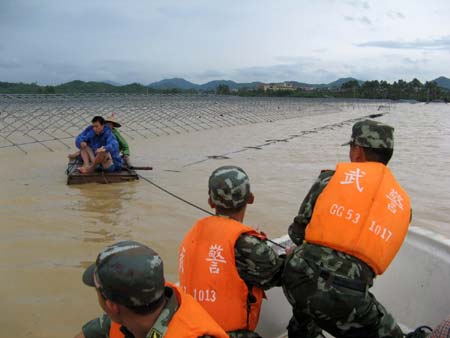 Soldiers of the local frontier defence troop rescue trapped residents in Zhao'an County, southeast China's Fujian Province, on June 22, 2009. Affected by tropical storm Linfa, the third this year, heavy rainstorm hit Zhao'an county on Sunday night. Over 100 residents trapped by floods have all been transferred to safe areas by Monday afternoon. 