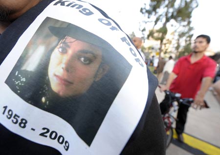 A fan wears a t-shirt with a picture of Michael Jackson while mourning the American pop icon in Los Angeles, the United States, on June 25, 2009. Michael Jackson, the 50-year-old former 'King of Pop', was announced dead here Thursday at a hospital after suffering a heart attack at his rented home in a wealthy Los Angeles suburb.