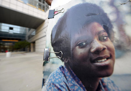 A fan holds a poster with a picture of Michael Jackson while mourning the American pop icon in Los Angeles, the United States, on June 25, 2009. Michael Jackson, the 50-year-old former 'King of Pop', was announced dead here Thursday at a hospital after suffering a heart attack at his rented home in a wealthy Los Angeles suburb.