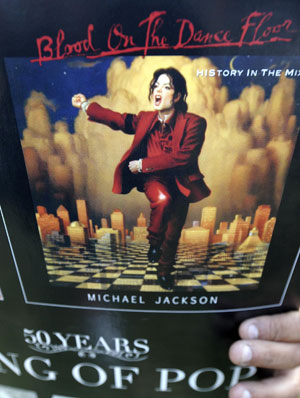 A fan holds a poster with a picture of Michael Jackson while mourning the American pop icon in Los Angeles, the United States, on June 25, 2009. Michael Jackson, the 50-year-old former 'King of Pop', was announced dead here Thursday at a hospital after suffering a heart attack at his rented home in a wealthy Los Angeles suburb. 