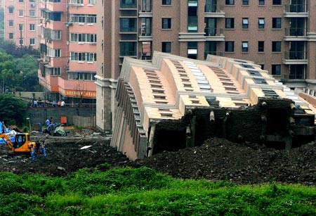 Photo taken on June 27, 2009 shows the scene of a toppled building in Shanghai, China. A 13-storey building under construction in the 'lotus riverside' neighborhood of Minhang district fell down entirely early Saturday morning. The accident killed one person. The cause of the accident is under investigation.