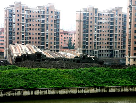 Photo taken on June 27, 2009 shows the scene of a toppled building in Shanghai, China. A 13-storey building under construction in the 'lotus riverside' neighborhood of Minhang district fell down entirely early Saturday morning. The accident killed one person. The cause of the accident is under investigation. 