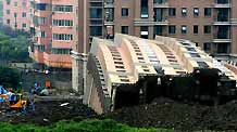 Photo taken on June 27, 2009 shows the scene of a toppled building in Shanghai, China. A 13-storey building under construction in the 'lotus riverside' neighborhood of Minhang district fell down entirely early Saturday morning. The accident killed one person. The cause of the accident is under investigation.