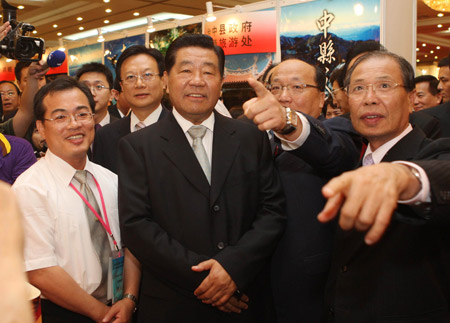Jia Qinglin (2nd L, front), chairman of the National Committee of the Chinese People's Political Consultative Conference (CPPCC), visits an exhibition of farm produce and tourist attractions from Taichung City and Taichung, Changhua and Nantou counties of southeast China's Taiwan Province, in Beijing, capital of China, on June 27, 2009.