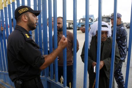 A Hamas policeman stands guard as Palestinians wait to cross into Egypt through the Rafah border crossing in the southern Gaza Strip, on June 27, 2009. The Egyptian authorities reopened, partially, the Rafah crossing at the border with the Palestinian territory of Gaza Strip on Saturday for three days. 