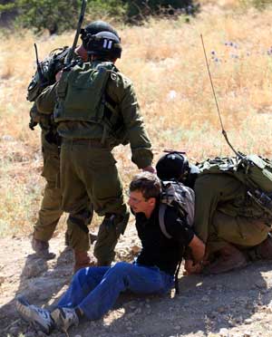 Israeli soldiers detain an activist in the West Bank village of Safa near Hebron on June 27, 2009. At least 20 pro-Palestinian activists were detained Saturday during a demonstration which later became a scuffle against Jewish settlements in the West Bank villages near Hebron.