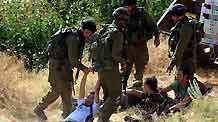 Israeli soldiers detain an activist in the West Bank village of Safa near Hebron on June 27, 2009. At least 20 pro-Palestinian activists were detained Saturday during a demonstration which later became a scuffle against Jewish settlements in the West Bank villages near Hebron.