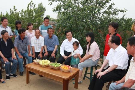 Chinese President Hu Jintao (C) talks with residents at Dongsheng Village in Wuliming Town of Zhaodong City, northeast China's Heilongjiang Province. President Hu Jintao made an inspection tour in Heilongjiang Province on June 26-28, 2009.