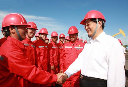 Chinese President Hu Jintao (1st R) visits workers at the Daqing Oilfield in northeast China's Heilongjiang Province. 