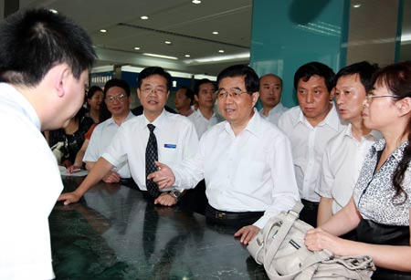 Chinese President Hu Jintao talks with a staff member of a labor force service center in Harbin, capital of northeast China's Heilongjiang Province.