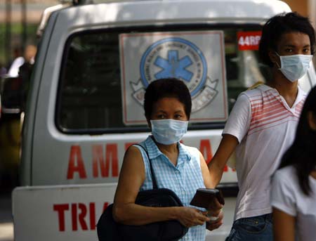 People wearing facial masks walk out of a hospital in Manila, capital of the Philippines, on June 29, 2009. The total number of confirmed cases of A/ H1N1 flu has risen to 604 in the Philippines as far as Sunday night, according to figures released by the Philippine Ministry of Health.