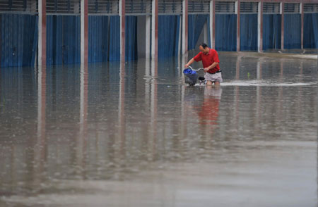 A Chinese man pushes his bicycle in deep rainwater on a flooded street in Wuhan, capital city of central China's Hubei Province, on June 30, 2009. The city has been hit by seasonal summer rainfalls for days. 