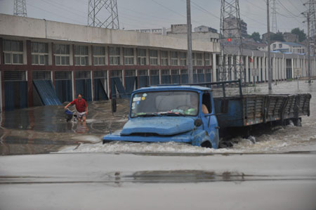 A truck drives in deep rainwater on a flooded street in Wuhan, capital city of central China's Hubei Province, on June 30, 2009. The city has been hit by seasonal summer rainfalls for days. 