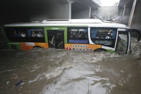 A city bus drives in deep rainwater on a flooded street in Wuhan, capital city of central China&apos;s Hubei Province, on June 30, 2009. The city has been hit by seasonal summer rainfalls for days. 