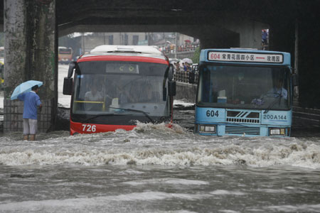 Two buses drive in deep rainwater on a flooded street in Wuhan, capital city of central China&apos;s Hubei Province, on June 30, 2009. The city has been hit by seasonal summer rainfalls for days.