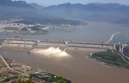 Photo taken on July 1, 2009 shows the Three Gorges Dam opening two deep-holes and a trash way hole for sluicing the mounting flood water, in Yichang, central China's Hubei Province. The Three Gorges Reservoir has high influx of flooded water along with the arrival of Yangtze River's main flood season with recent days' persistent rainfalls. 