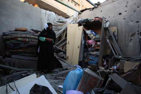 A Palestinian woman inspects her damaged house after an Israeli attack in central Gaza strip on July 2, 2009. Israel shelled the Hamas-controlled Gaza on Thursday, killing a Palestinian teenage girl, hospital workers said. An Israeli military spokeswoman said there had been clashes between soldiers and Palestinian militants near a border crossing in the area.