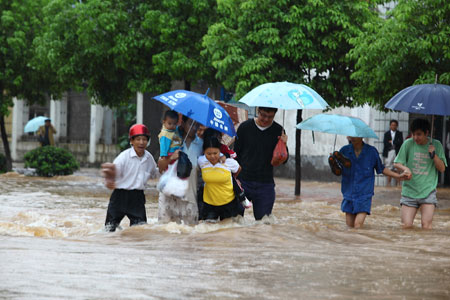 Pedestrians move on the water-logging road in Pingxiang City, southeast China's Jiangxi Province, on July 2, 2009. A heavy rain hit Pingxiang City from Wednesday night to Thursday morning. The city faced frequent thunder storm recently.