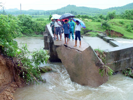 Villagers check the bridge damaged by the flood in Le'an County of east China's Jiangxi Province, on July 2, 2009. A storm hit Le'an County from Wednesday to Thursday.