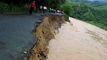 The road is eroded by the floods in Sanjiang County in southwest China's Guangxi Zhuang Autonomous Region, on July 2, 2009. A heavy storm hit Gaoji Village, Heping Village, Danzhou Village etc. in Sanjiang County from Wednesday night to Thursday morning, which caused floods in these areas. The rescuing work was undergoing.