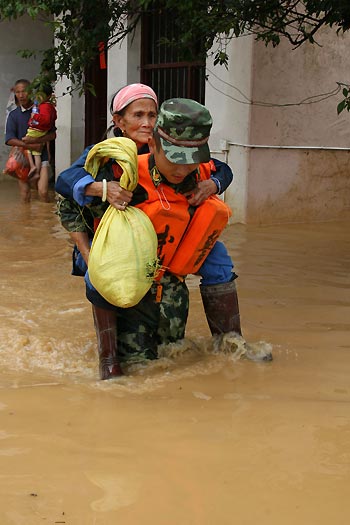 A policeman carries an old woman in evacuation in Xincheng Township of Dayu County, east China's Jiangxi Province, on July 4, 2009. Rainstorms have swept Jiangxi since Tuesday, leaving two people dead, one missing and over 3.9 million others affected.