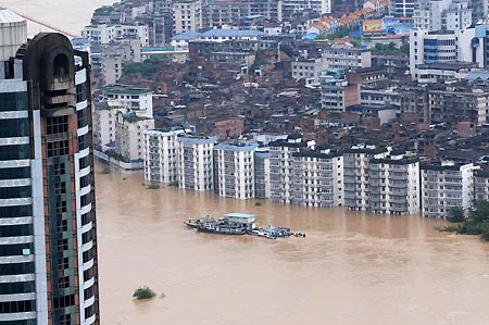 Photo taken on July 4, 2009 shows the city zone along the Liujiang River in Liuzhou, southwest China's Guangxi Zhuang Autonomous Region. The water level of the Liujiang River rose to 89.28 meters on Saturday, exceeding the warning level by 6.78 meters. 