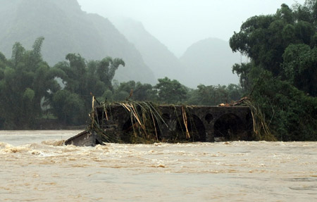 The Qiaoben Bridge destoryed in flood is seen in Qiaoshan Town of Luocheng County, southwest China's Guangxi Zhuang Autonomous Region, on July 4, 2009. Floods caused by rainstorms since early the week have left four people missing and 11,845 others displaced in Guangxi.