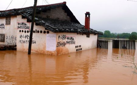 A house is submerged in water in Jingba Town of Nankang City, east China's Jiangxi Province, on July 4, 2009. Rainstorms have swept Jiangxi since Tuesday, leaving two people dead, one missing and over 3.9 million others affected. 