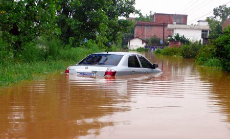 A car is submerged in water in Jingba Town of Nankang City, east China's Jiangxi Province, on July 4, 2009. Rainstorms have swept Jiangxi since Tuesday, leaving two people dead, one missing and over 3.9 million others affected. 