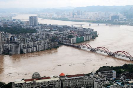 Photo taken on July 4, 2009 shows the city zone along the Liujiang River in Liuzhou, southwest China's Guangxi Zhuang Autonomous Region. The water level of the Liujiang River rose to 89.28 meters on Saturday, exceeding the warning level by 6.78 meters.