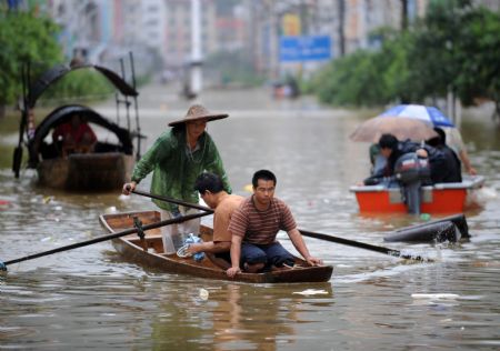 Local people paddle boats on a flooded street in Rongshui Yao Autonomous County, southwest China's Guangxi Zhuang Autonomous Region, on July 4, 2009. 