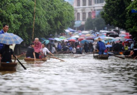 Local people paddle boats on a flooded street in Rongshui Yao Autonomous County, southwest China's Guangxi Zhuang Autonomous Region, on July 4, 2009.