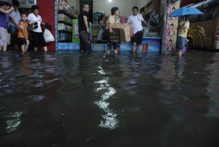 The local shoppers stray at the flooded grocery stores in downtown Yingtan city in south China's Jiangxi Province, on July 4, 2009. Heavy rain and storm struck the city saturday paralysing part of the city's communications.