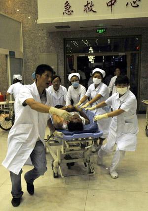 An injured man is carried to an urgent care center in Urumqi, capital of northwest China&apos;s Xinjiang Uygur Autonomous Region on July 5, 2009.(Xinhua/Shen Qiao)